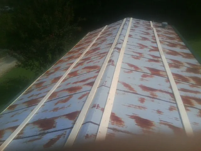 Rusted metal roof panels with new wood purlins before replacement — Storm Damage Roof Repair in Orange Lake by Roofing Brothers